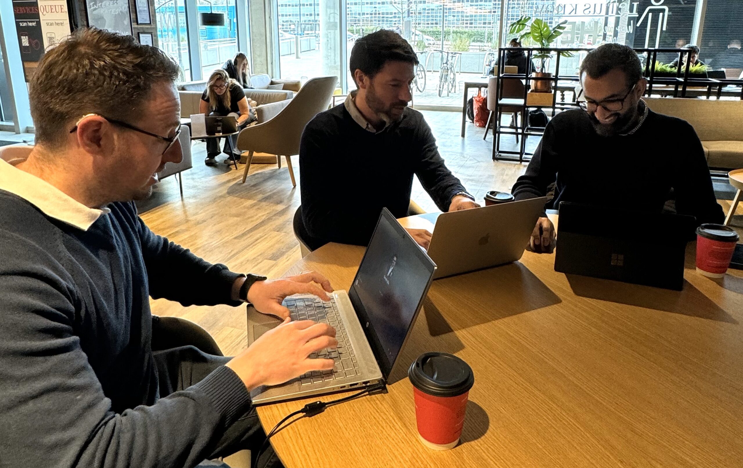 Team at work at a desk with laptops